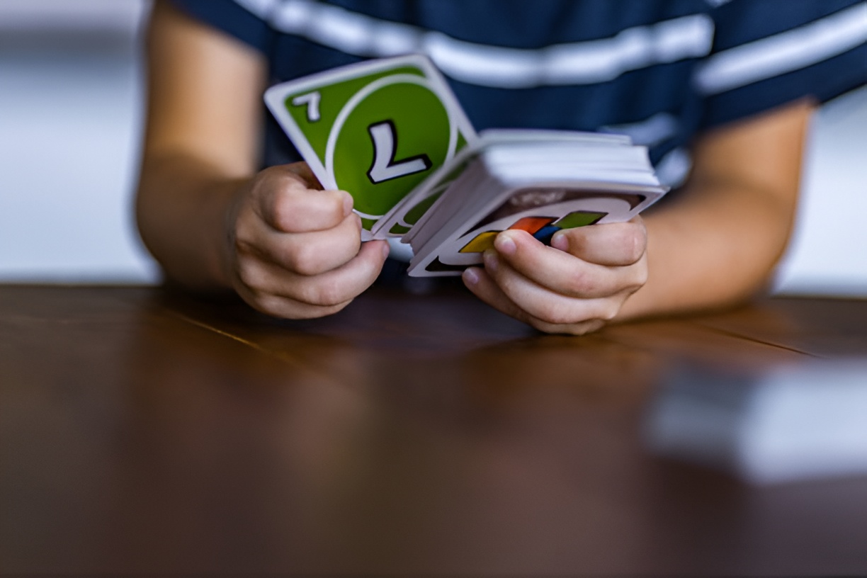boy holding a deck of Uno cards