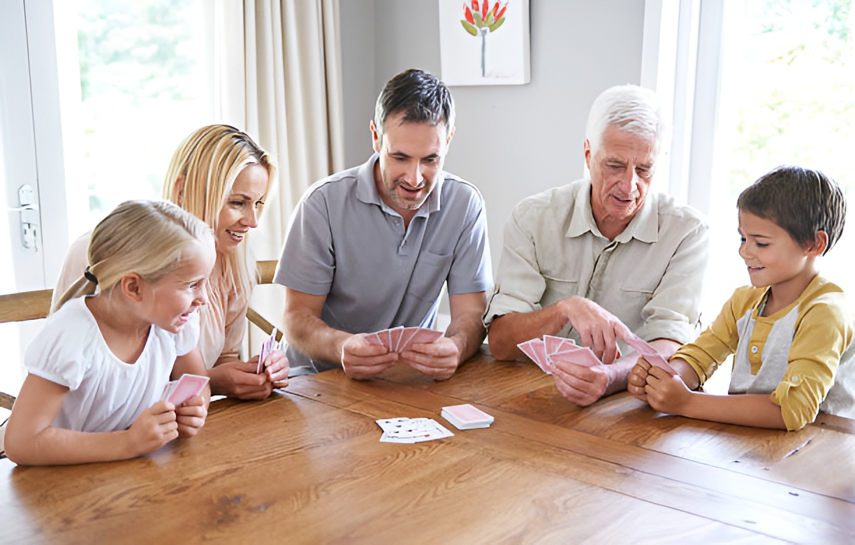 kids playing a card game with their parents and grandfather